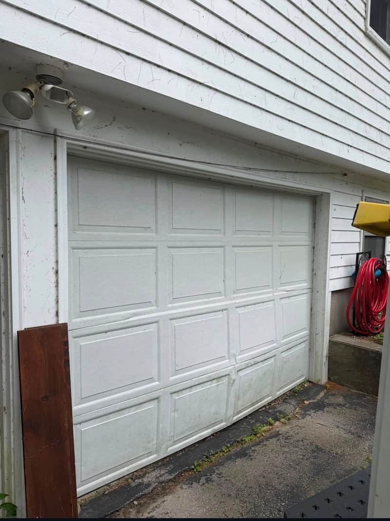 Aging white sixteen-panel double garage door, dirty and sagging, before replacement